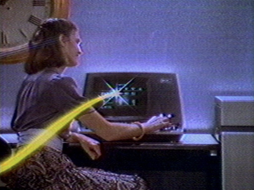 Woman sitting at a desk and using old computing machine.